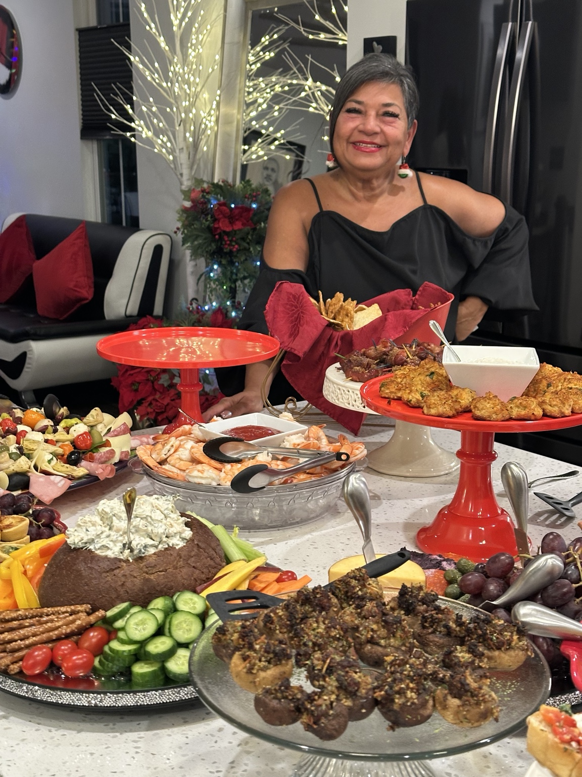 Edie behind a full table of appetizers and platters